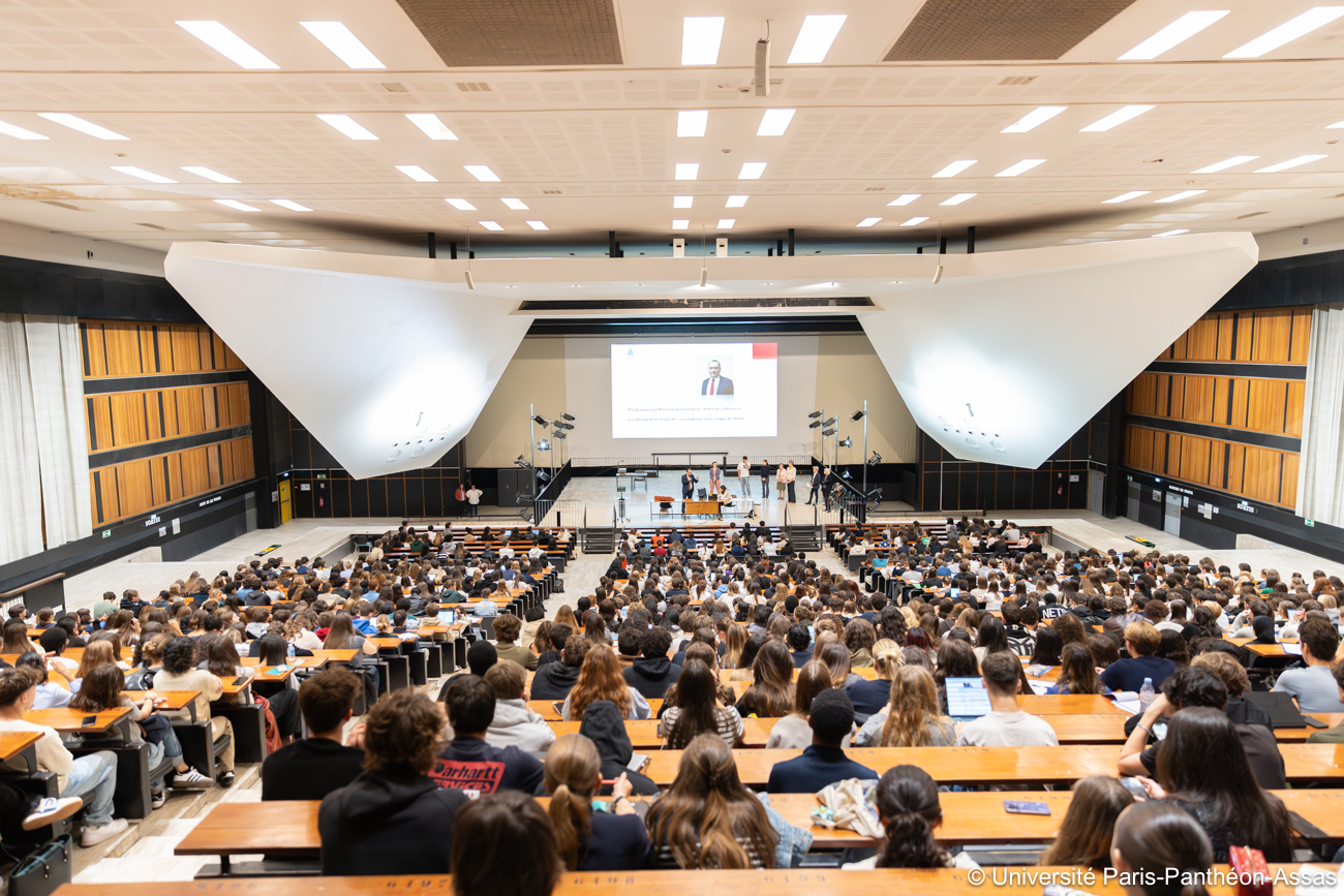 Des étudiants qui écoutent le discours de présentation dans un amphithéatre lors de la journée d'acceuil